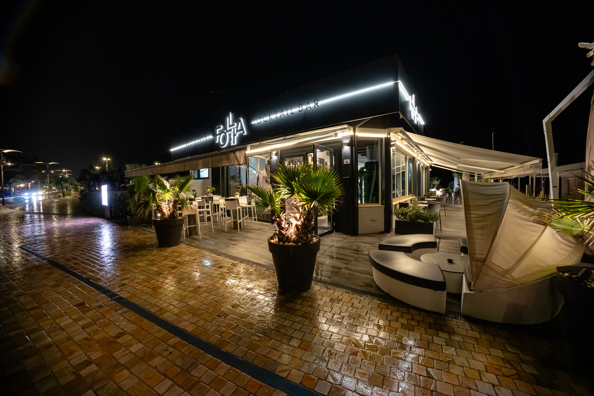Follia Beach di sera, con le insegne illuminate e la veranda