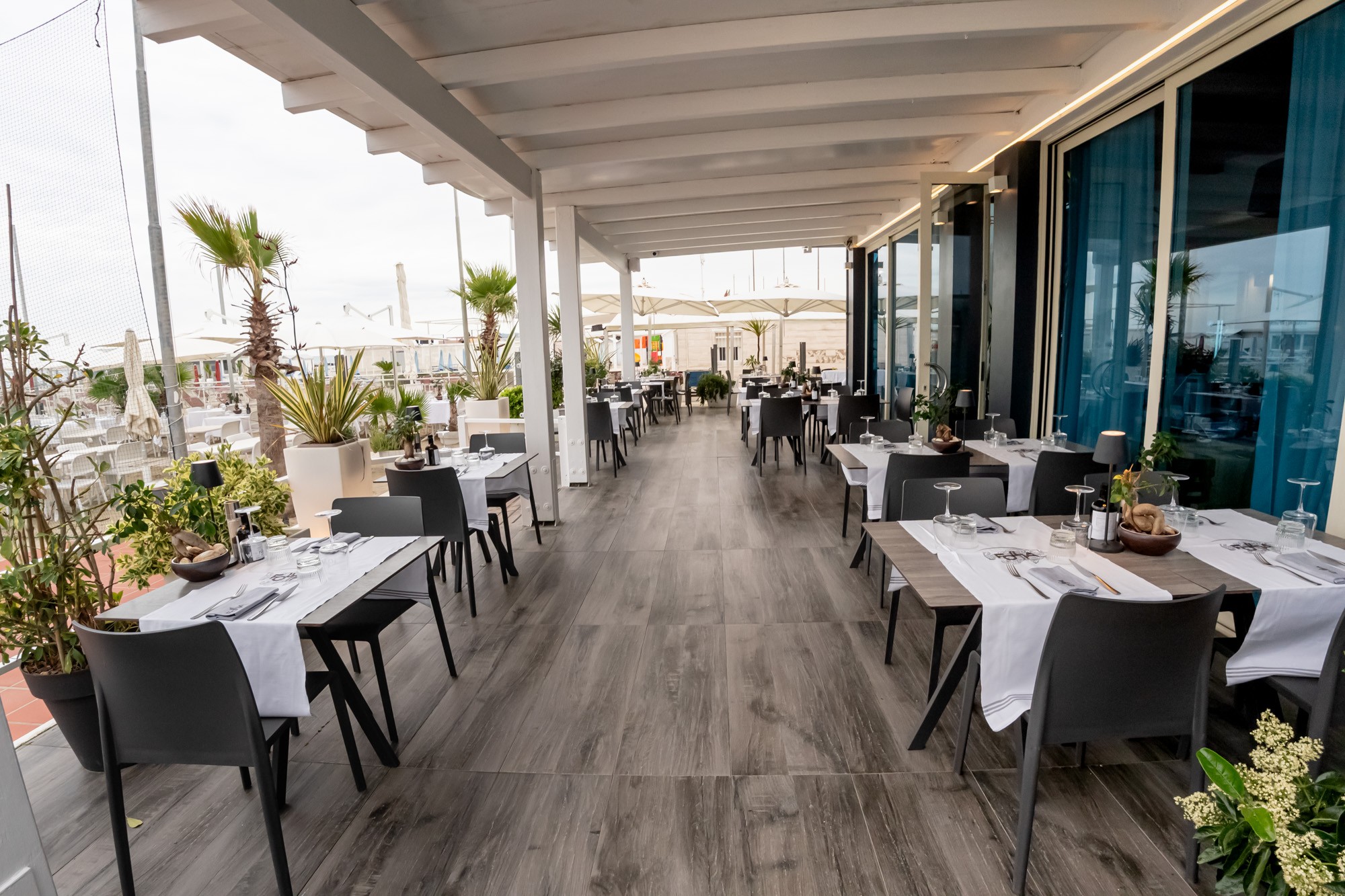 La veranda apparecchiata di Follia Beach, aperta verso la zona esterna